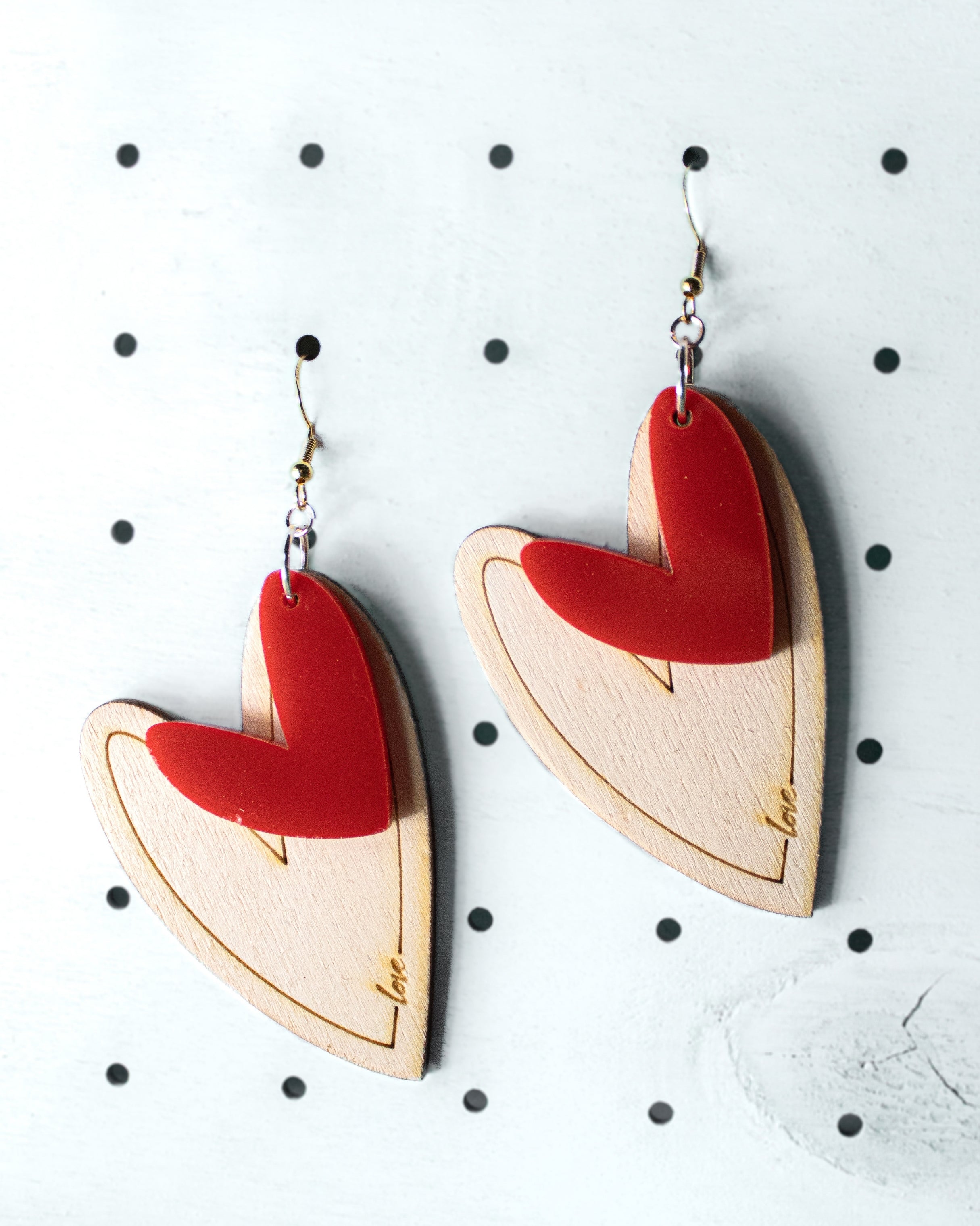 Orecchini a cuore in plexiglass fucsia e legno di pioppo inciso con scritta love